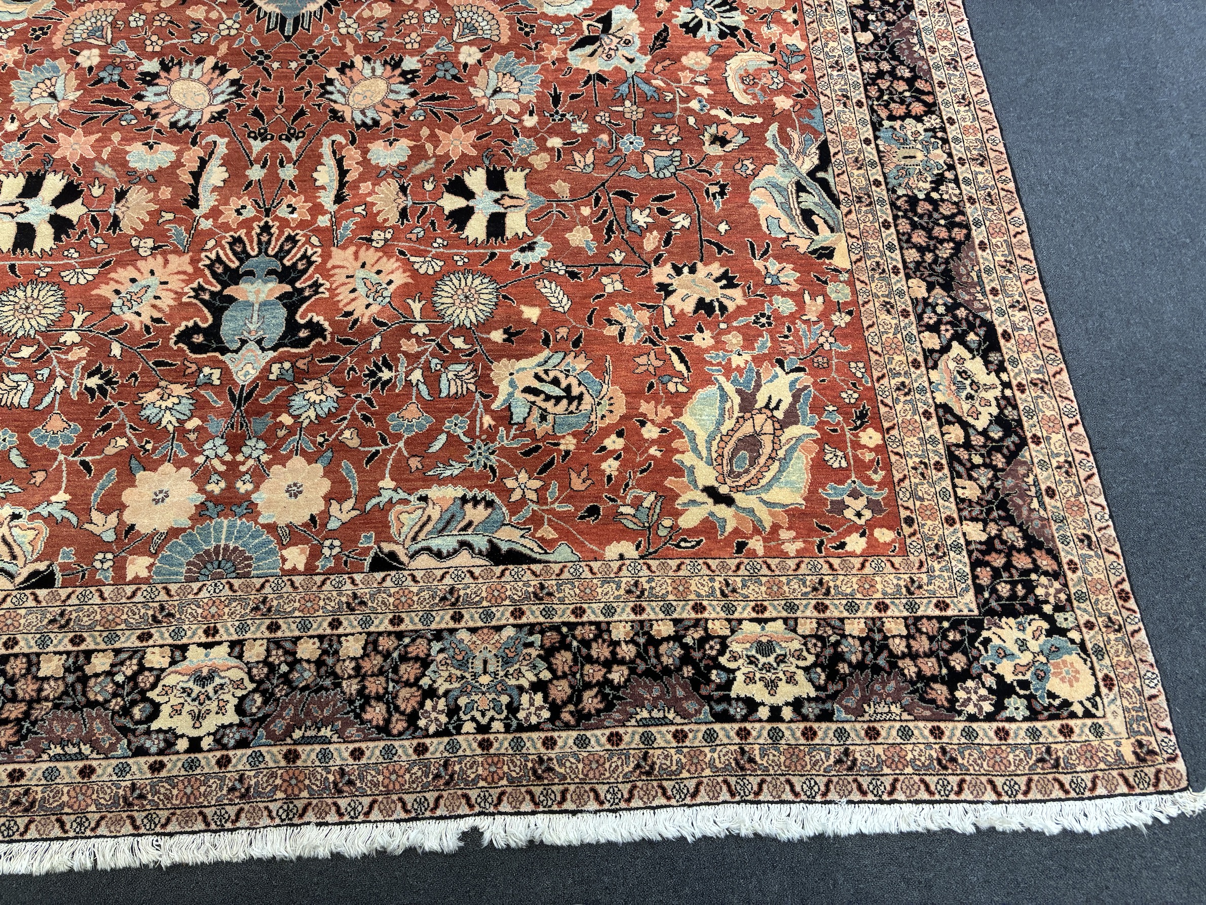 A Tabriz brick red ground gallery carpet 575 x 300cm
